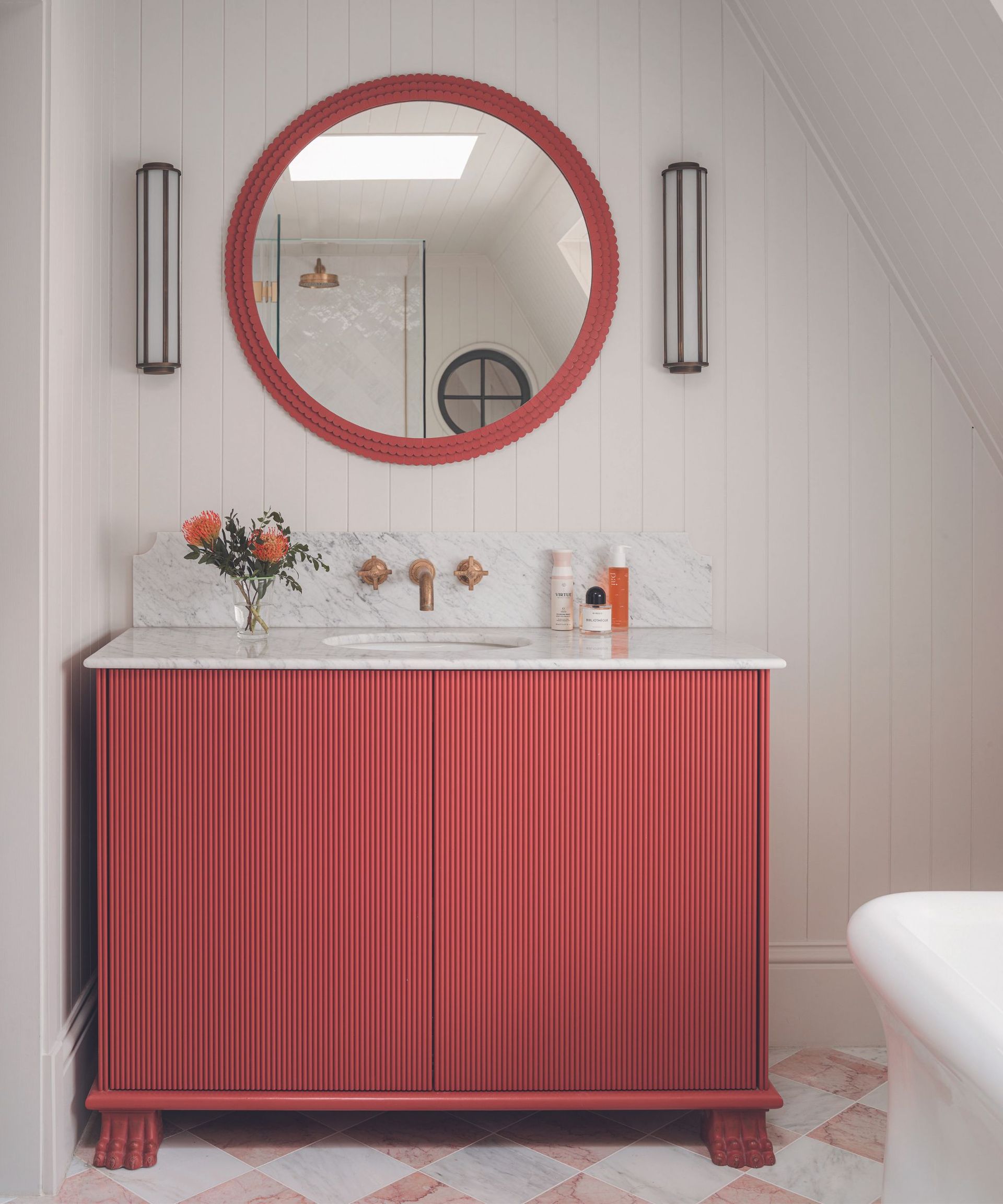 Small bathroom with cream walls and red vanity and mirror