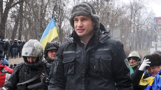 Head of UDAR (Punch) party and one of the leaders of the opposition Vitali Klitschko (R) walks in front of a rank of police after violent clashes in central Kiev on January 21, 2014. A new se