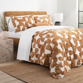 A patterned quilt set on a bed