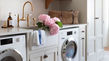 Neutral laundry room with washing machine, tumble dryer and Belfast sink