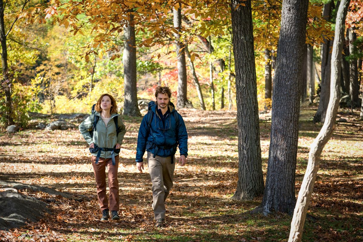 Helen and Jake walking through the woods together.