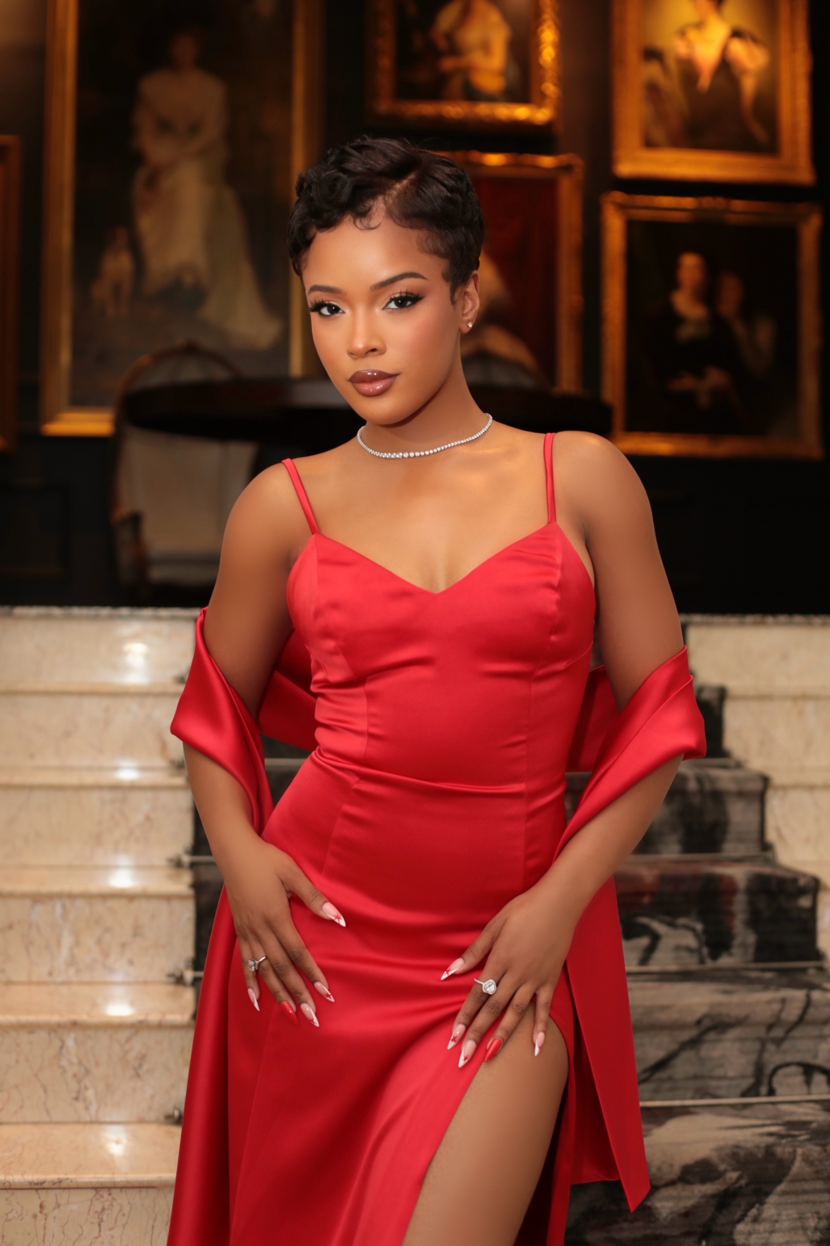 Actress Maleah Joi Moon wears a red gown and shawl while posing in a museum at Netflix's 'A Different World' premiere.