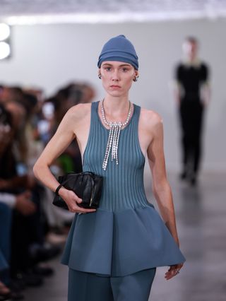 Jil Sander model wears a blue peplum top.