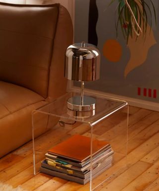 An acrylic nightstand in a small brown living room