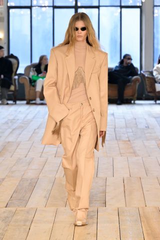 Woman in Sportmax suit and sunglasses on runway