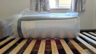The Emma Luxe Cooling Mattress rolled and vacuum-packed in plastic wrapping