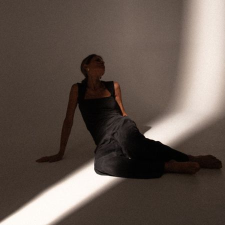 A woman stretching and in the shadows