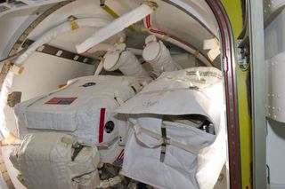 The feet and lower legs of NASA astronaut Michael Fincke in the airlock prior to the STS-134 mission's second space walk, and Fincke's first for the flight so far, on May 22, 2011. A little later, astronauts Fincke and Andrew Feustel (left side of the fra