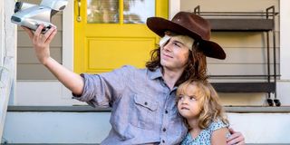 Carl and Judith taking a picture together in The Walking Dead.