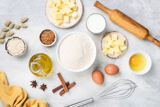 a table filled with flour, eggs, butter and other ingredients