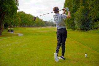 Dan Parker hitting a driver while testing the G/FORE G/18 shoes