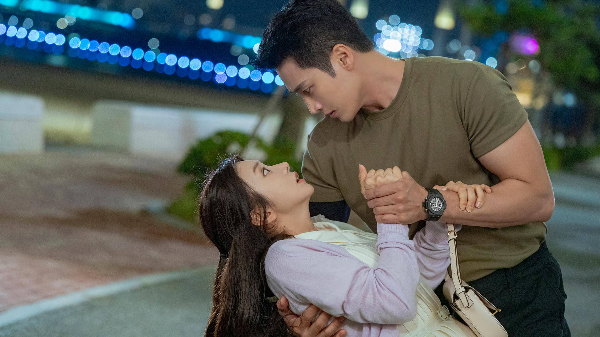 A man (actor Ahn Bo-hyun) holds a woman (actress Lee Joo-bin) in a dip, as the pair stands outdoors in a park at night. A still from the Prime Video K-drama 'Spring Fever.' 