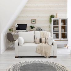 A small white sofa bed in a contemporary white living room
