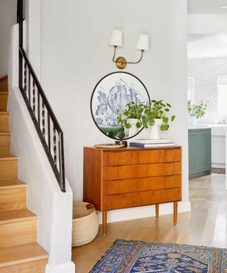 Mid-century modern entryway with a wood dresser and round mirror