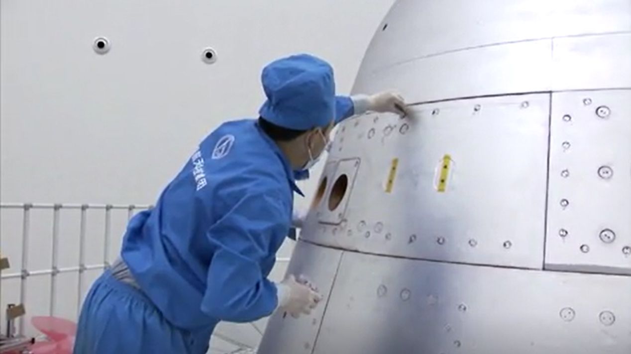 China's next-generation space capsule for astronauts is prepared for its uncrewed test flight on a Long March 5B rocket in these stills from a CCTV state news video. The capsule launched May 5, 2020.