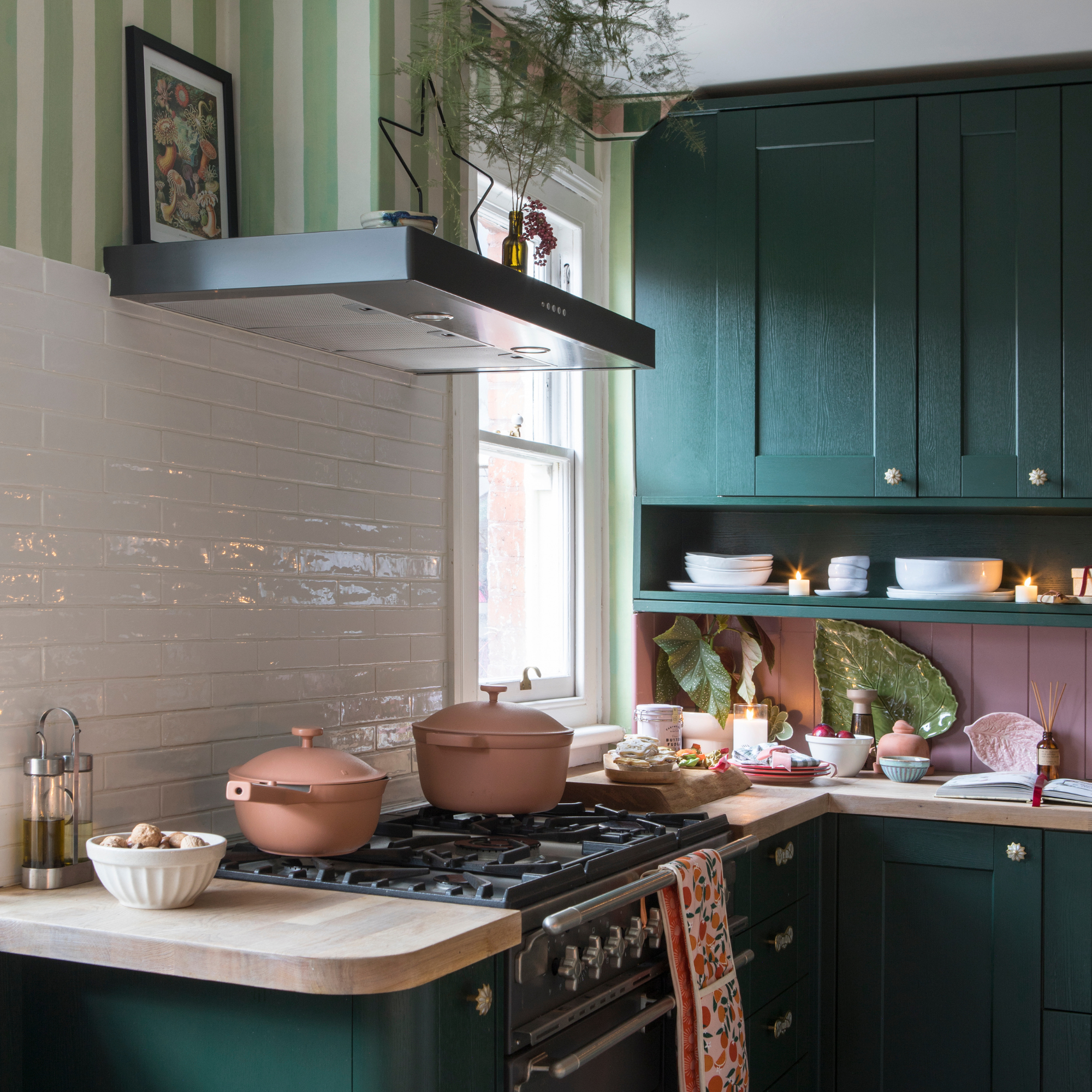 Our PLace pan and pot in Rust on a hob in a modern green and pink kitchen.