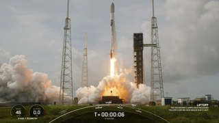 A white and black rocket launches to space under cloudy weather