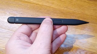 Microsoft Surface Slim Pen 2 review; a person's hand holds a stylus pen
