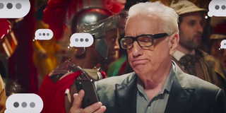 Martin Scorsese stares at his cell phone in disappointment as text message bubbles with three dots a