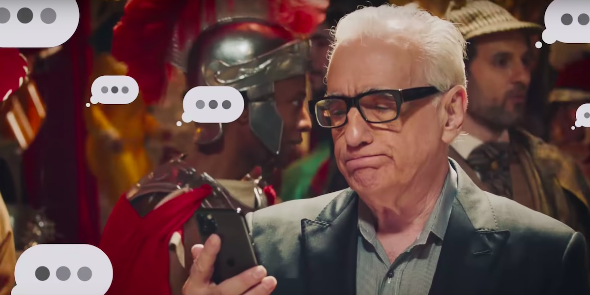 Martin Scorsese stares at his cell phone in disappointment as text message bubbles with three dots a