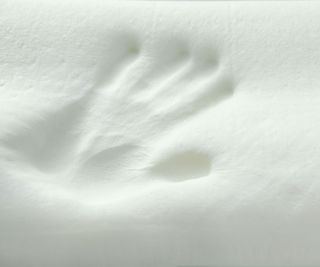 A close up of an imprint of a hand in memory foam