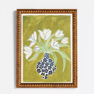 A gold picture frame with a picture of a vase with flowers.