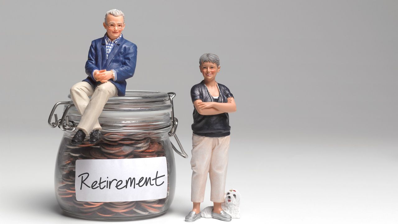 Retired couple miniature figurines standing next to a glass car filled with coins marked &quot;Retirement&quot;