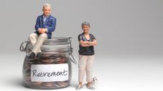 Retired couple miniature figurines standing next to a glass car filled with coins marked "Retirement"