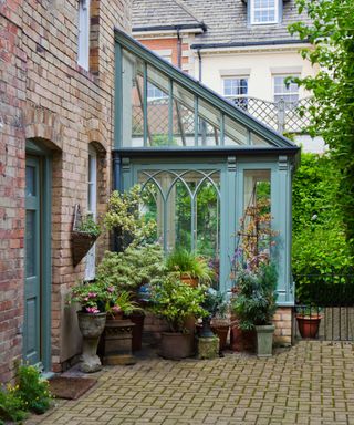 A modest lean-to conservatory on this Victorian townhouse provides just enough room for year-round indoor gardening. The inclusion of Gothic arches are a charming addition to the design.