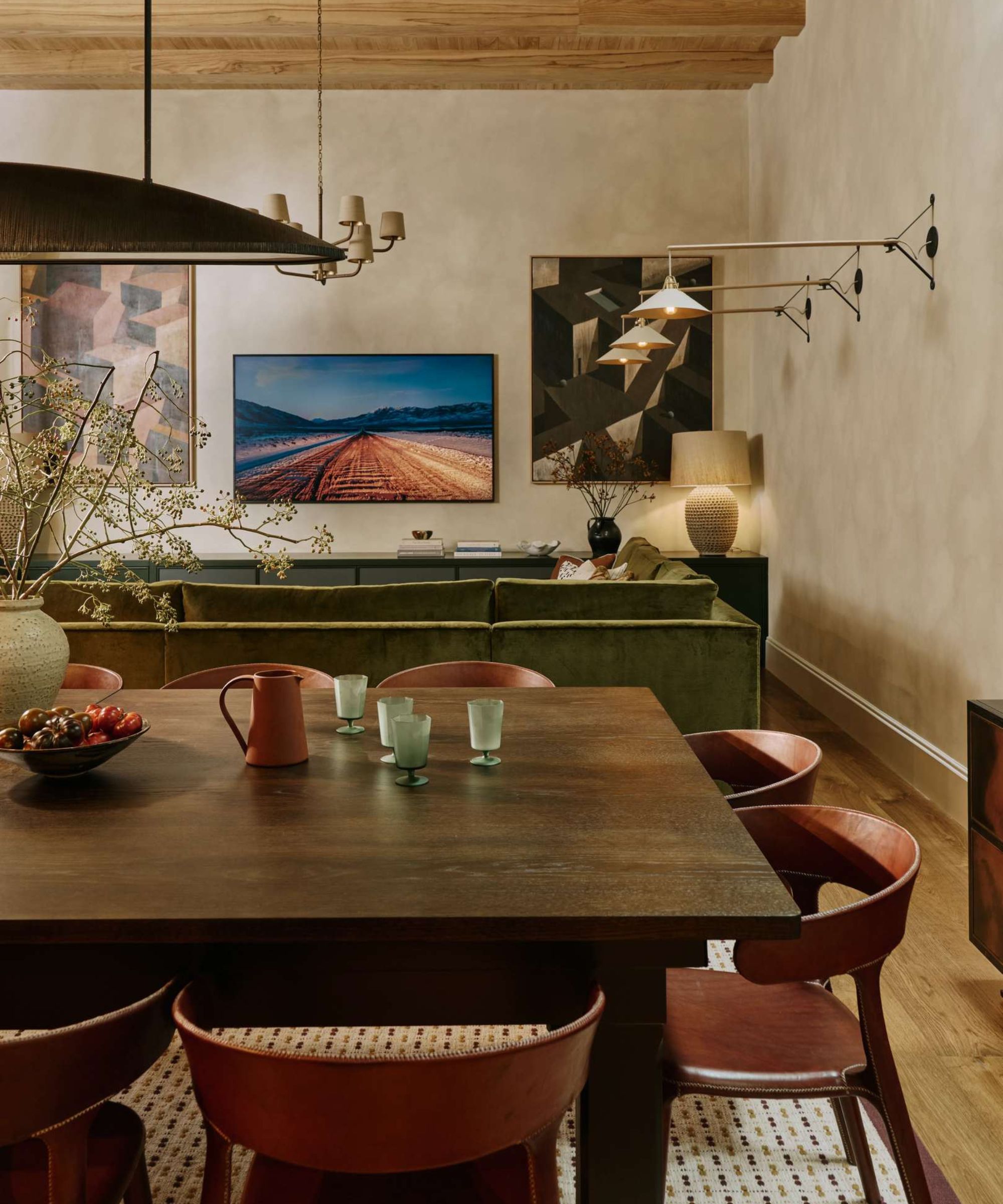 a large basement with bauwerk painted walls styled with mid-century sitting room and dining room zones and layered lighting