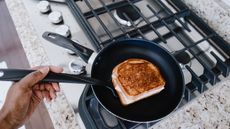 High angle view of woman making a pan-toasted turkey sandwich