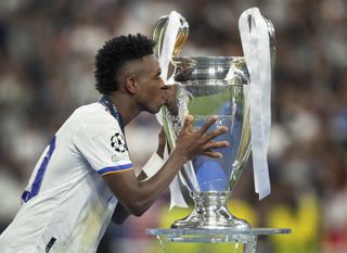 Real Madrid's Vinicius Junior kisses the Champions League trophy after victory against Liverpool in the 2022 final.