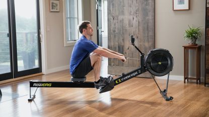 Concept2 RowErg review: image shows man on Concept2 RowErg indoor rower