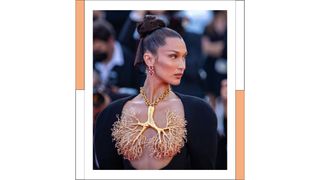 Model Bella Hadid wears a gold, tree necklace breastplate as she attends the "Tre Piani (Three Floors)" screening during the 74th annual Cannes Film Festival on July 11, 2021 in Cannes, France