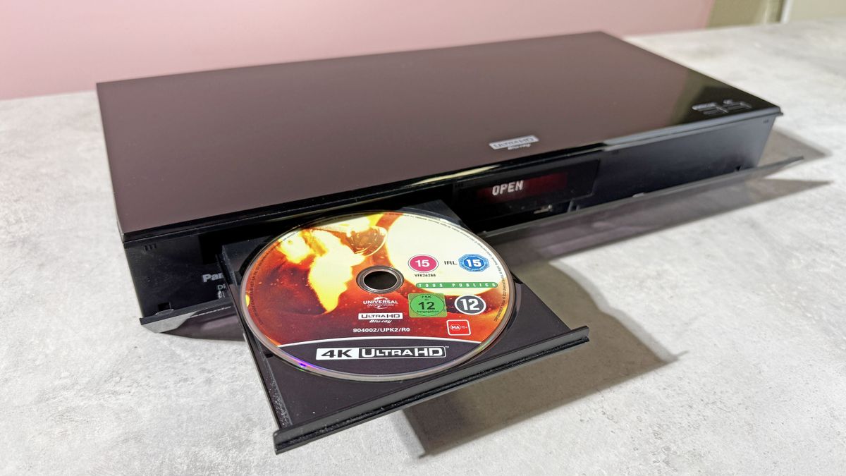 A Panasonic DP-UB820 4K Blu-ray player, with its disc tray open, and copy of Oppenheimer on 4K Blu-ray disc in the tray