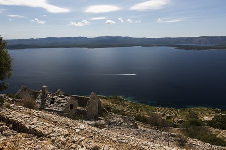 The view from Stina Winery: crumbly buildings and blue water in the background