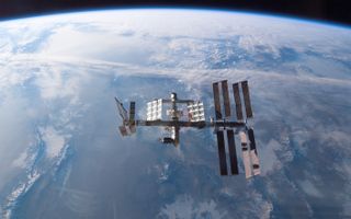 The International Space Station hangs in front of the curvature of Earth.