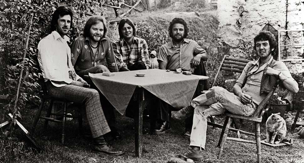 Slim Chance seated around a garden table