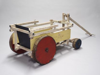 A beach buggy by Gerrit Rietveld made of wood and painted red, yellow and blue, seen at TEFAF Maastricht 2026