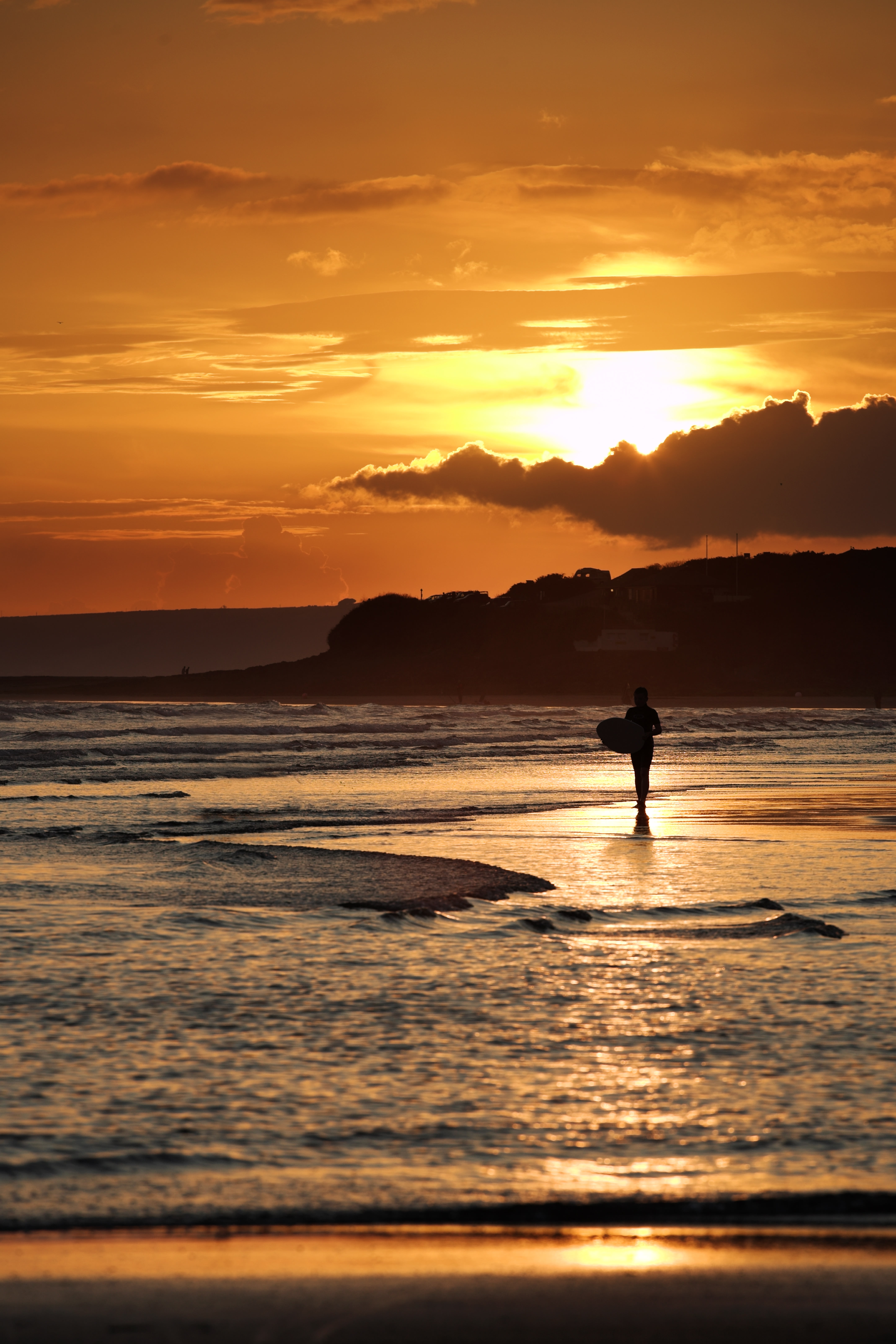 A lone surfer at sunset on Bantham beach