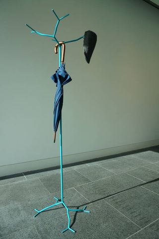Enchanted Coat Stand with a blue tree branch design, an umbrella and hat hanging off of it