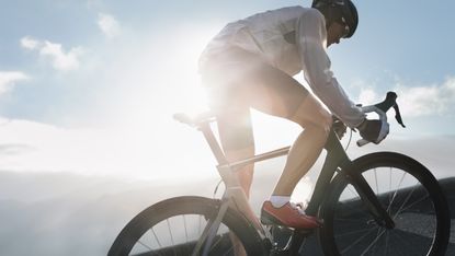 Silhouette of cyclist riding up in high mountains