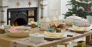 Christmas table with cream house lanterns used as a centrepiece idea