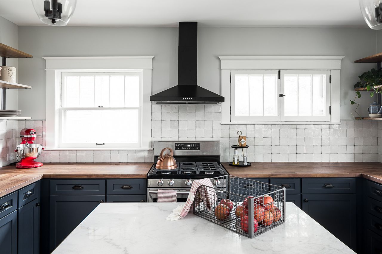 A kitchen with white walls and zellige tiles