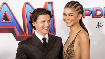 Zendaya and Tom Holland laugh on a red carpet