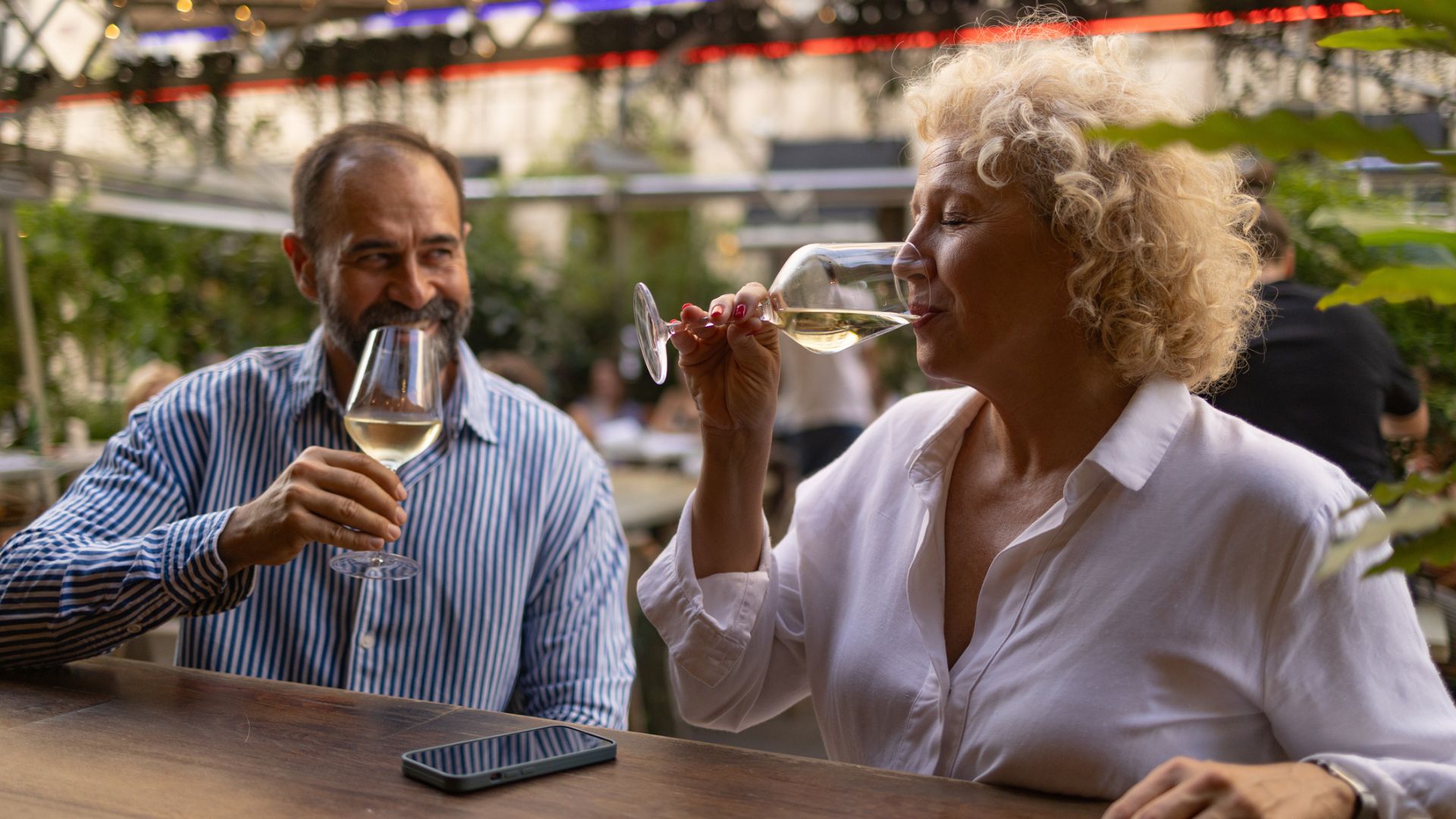 Couple having a glass of wine together at a bar, after meeting on a dating sites for over 50