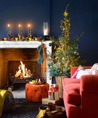 Cozy living room with fireplace and lit fire, orange sofa and footstool, christmas tree decorated in colorful ornaments
