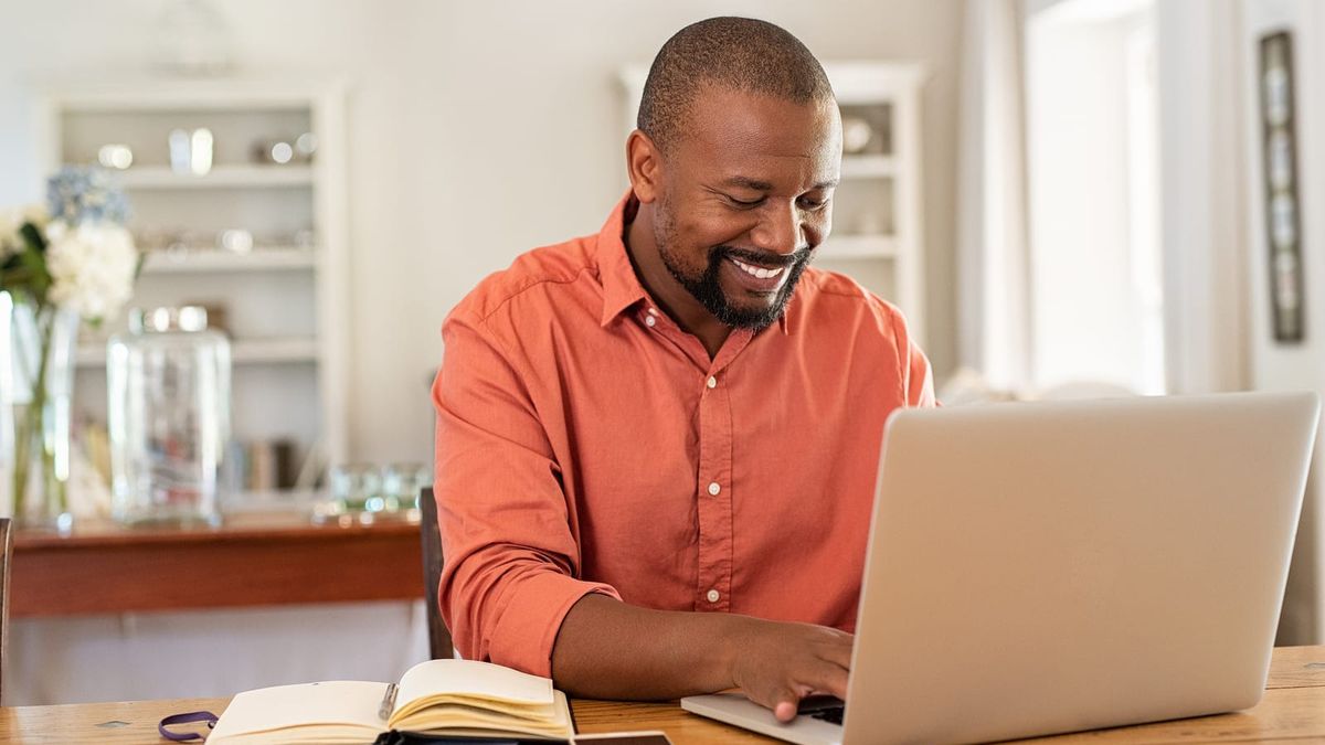 Man sitting at table using laptop