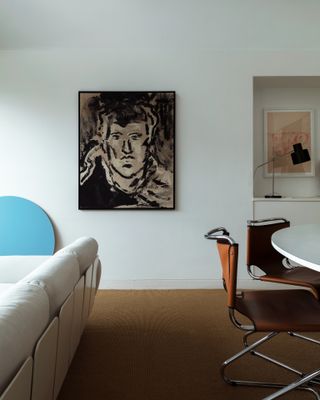 Cream couch, brown dining room chair, white walls and modern art in Barbican apartment