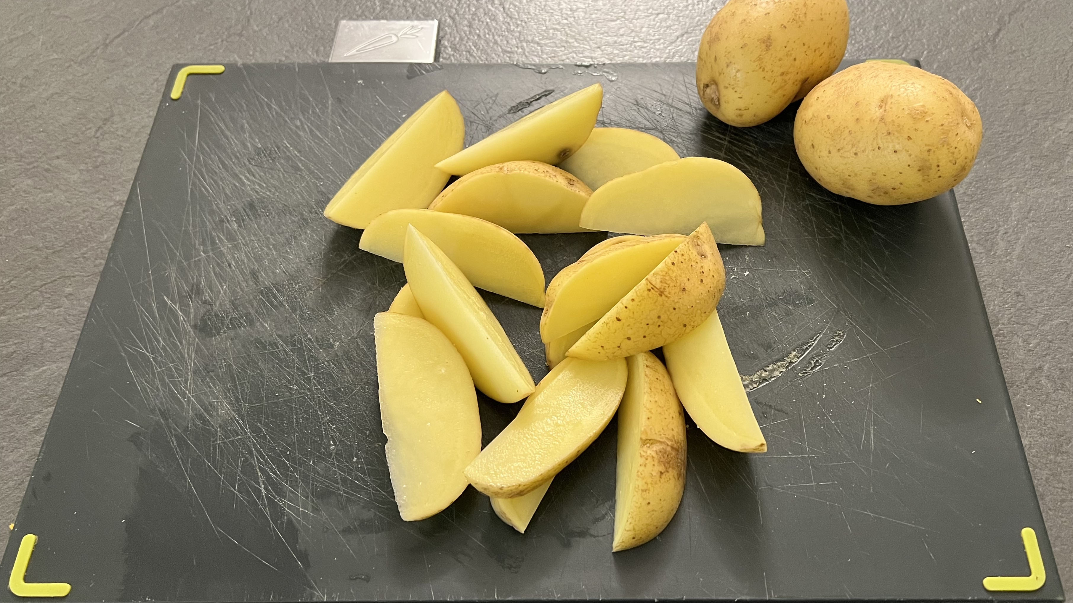 Chopped potato wedges on a cutting board